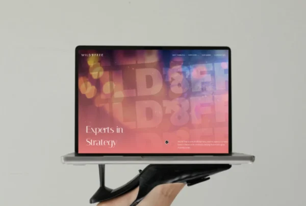 Creative digital design process showing bold branding visuals and website mockups on screen.