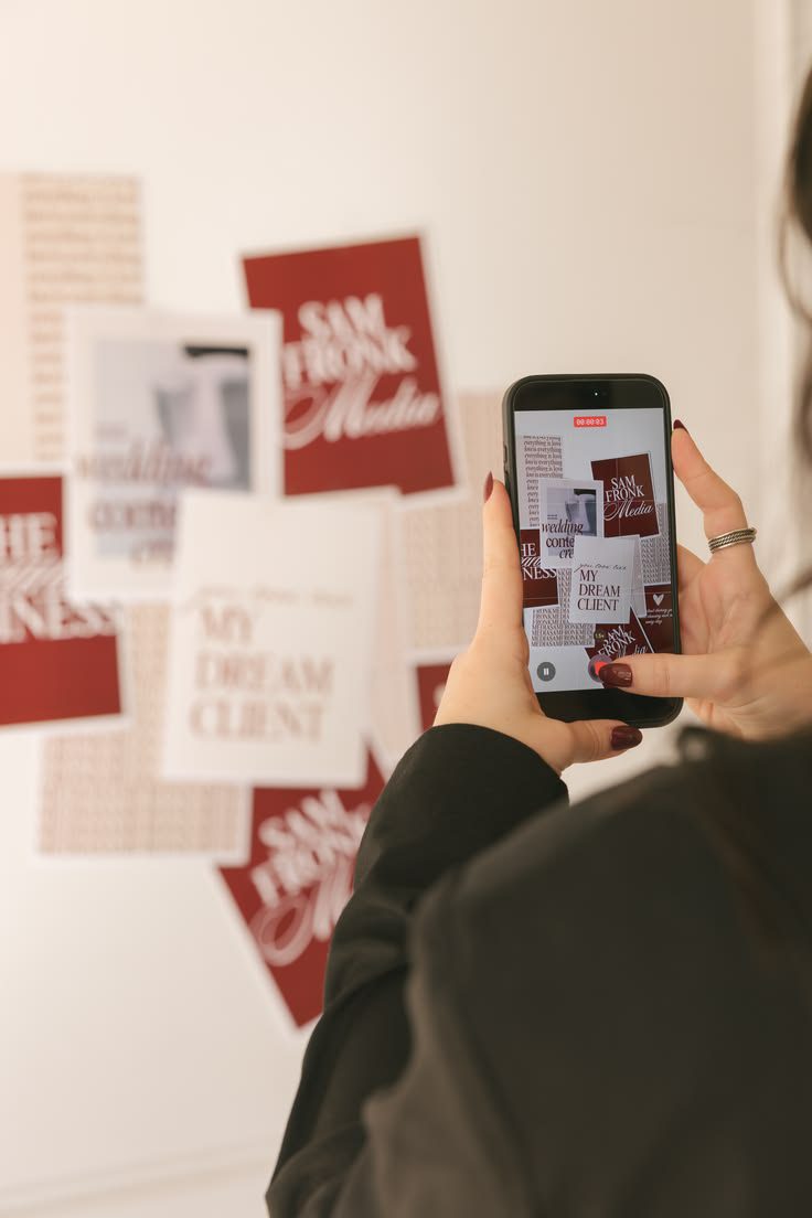 Woman photographing posters on a wall representing social media management in Newcastle.